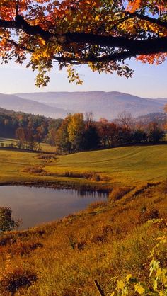 a scenic view of the mountains and lake in autumn time with fall foliage on the trees