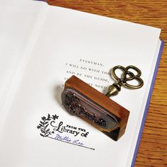 an open book with a wooden keychain and some keys on top of it