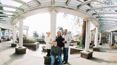 the family is posing for a photo under the pergolated roof at the park