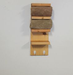 a wall mounted shelf with three pieces of wood stacked on top of eachother