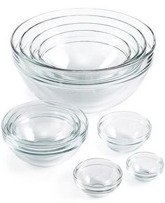 clear glass bowls and plates on a white background with one empty bowl in the middle