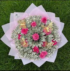 a bouquet of pink roses and butterflies on top of green grass