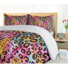 a bed with colorful leopard print comforter and pillows