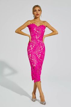 a woman in a bright pink dress is standing with her hands on her hips and looking off to the side