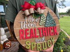 a man holding a wooden sign that says take them real thick and sprout