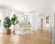 a living room filled with furniture and a white piano