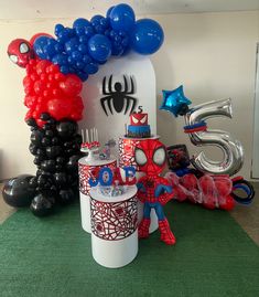 a spiderman birthday party with balloons and decorations