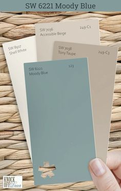 someone holding up some paint swatches in their hand with the words sw 521 moody blue on it