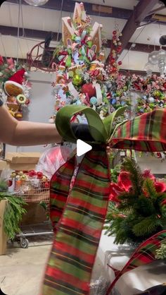 a person is wrapping christmas presents in red, green and white ribbons with bows on them