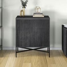 a black cabinet sitting on top of a hard wood floor next to a book shelf