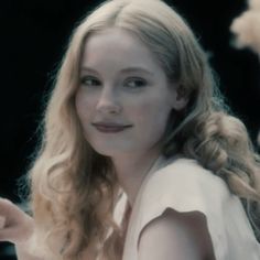 a woman with long blonde hair sitting at a table