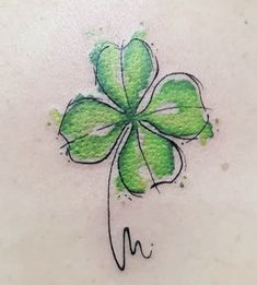 a four leaf clover tattoo design on the back of a woman's stomach,