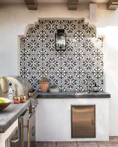 an outdoor kitchen with black and white tile