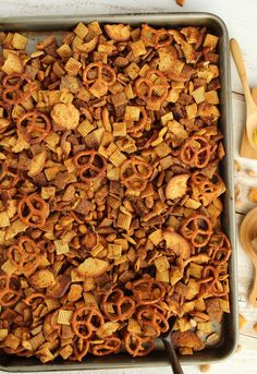 a baking pan filled with cheetos and pretzels