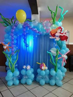 an under the sea themed balloon arch with balloons and fish on it for a birthday party