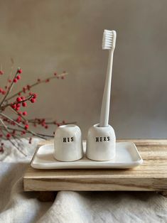 two toothbrushes sitting on a plate with the words he's next to them