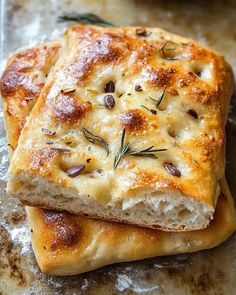 two pieces of bread with cheese and herbs on them