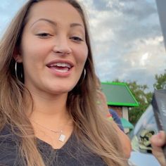 a woman with long hair is talking on her cell phone and smiling at the camera