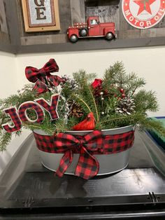 a metal bucket filled with pine cones and evergreens on top of a stovetop