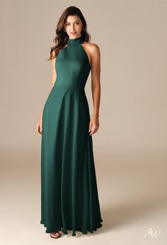 a woman wearing a long green dress with high neck and open back, standing in front of