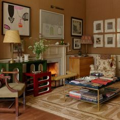 a living room filled with furniture next to a fire place and pictures on the wall