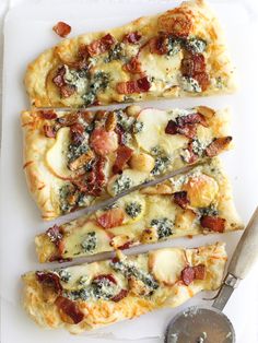 four slices of pizza sitting on top of a white cutting board