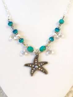 "Sparkling \"Star of the Sea\" beaded silver chain necklace featuring gorgeous 1 1/4\" x 1 3/8\" rhinestone starfish antique silver pendant. Surrounding the charm two-color Aqua designer Czech glass beads, lovely white Swarovski crystal pearls, turquoise Czech table cut beads, wire wrapped iridescent Czech glass teardrops, Czech vitrail (rainbow iridescent) beads, pewter and silver spacer beads. All strung on a pretty sparkly Sterling silver plate cable chain with unique easy to use handmade sil Silver Necklaces With Star Charm And Round Beads, Silver Necklace With Star Charm And Round Beads, Beach Jewelry In Silver With Rhinestones, Silver Rhinestone Beach Jewelry, Bohemian Silver Jewelry With Starfish Charm, Beach Silver Jewelry With Rhinestones, Bohemian Silver Necklace With Starfish Charm, Silver Rhinestone Jewelry For The Beach, Silver Beaded Ocean-inspired Jewelry