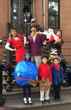 a group of people standing on the steps in front of a building wearing costumes for halloween