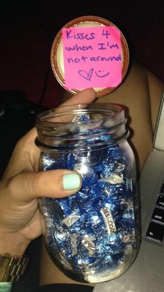 a person holding a jar filled with blue and white candies