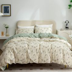 a bedroom with a bed, nightstands and pictures on the wall above it that is decorated in white and green