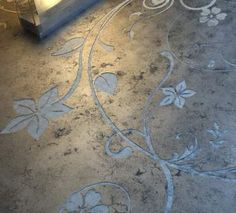 the floor is painted with white flowers and leaves on it's surface, while a lamp shines in the background