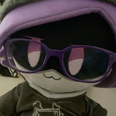 a stuffed animal wearing sunglasses and a purple hat with ears on it's head