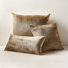 two gold pillows sitting next to each other