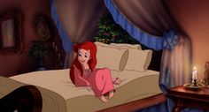 the little mermaid is laying on her bed