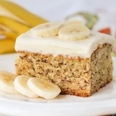 a piece of banana cake with frosting and sliced bananas