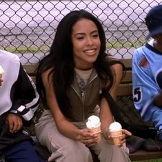 three people sitting on a bench eating ice cream