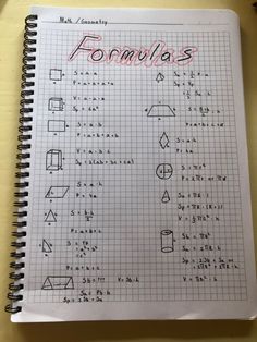 a notebook that has some writing on it with formulas written in red and black