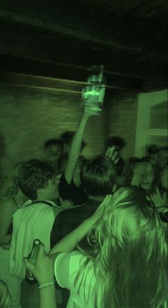 a group of people standing around each other in a room with one person holding up a cell phone