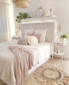 a bedroom with white walls and wooden flooring is decorated in neutral tones, such as pink