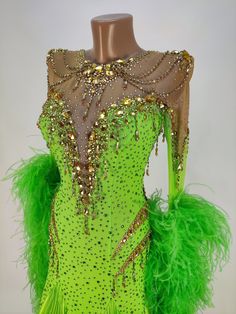 a green dress with gold sequins and feathers