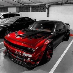 two cars parked in a parking garage with red and black paint splattered on them