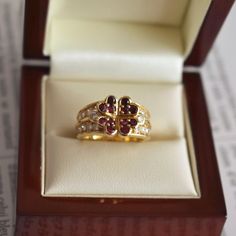 Vintage ring signed by Boucheron, crafted in 18-karat gold. It features a central flower composed of four heart-shaped rubies, flanked by two rows of brilliant-cut diamonds. The ring is signed Boucheron, numbered, and hallmarked. Weight: 9g Size: 51 FR (5.75 US - L UK) Metal: 18-karat Gold Stones: Diamonds and Rubies Boucheron Ring, Natural Ruby Ring, Ring Luxury, Yellow Gold Diamond Ring, Birthday Ring, 18k Yellow Gold Ring, Ruby Ring, Vintage Ring, Natural Ruby