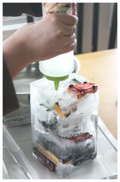 a person pouring something into a bag filled with ice cubes on top of a table