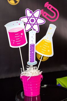 the science themed centerpieces are in a pink cup