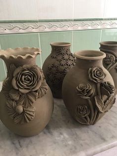 three vases sitting on top of a marble counter