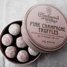 pink champagne truffles in a box on a bed