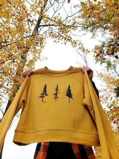 "Original \"Tree Trilogy\" graphic screen printed on a soft raglan pullover sweatshirt. This is a great gift for the tree hugger in your life! *Original Boomerang 360 Design Mustard Yellow & Brown OR Black & White AVAILABLE IN WOMEN'S S-XL Sweatshirt Specs: Bella/Canvas Pullover Poly/Cotton Fleece Raglan Loose Fit Sweatshirt 52% Combed and Ring-Spun Cotton 48% Polyester-Fleece Cropped Bound Neck Side Seamed Raglan Sleeve Contoured Seam on Sleeve Enjoy your new tree sweatshirt!" Outdoor Fall Crew Neck Top, Relaxed Fit Raglan Sleeve Sweatshirt With Graphic Print, Fall Letter Print Raglan Sleeve Sweatshirt, Fall Raglan Sleeve Sweatshirt With Letter Print, Fall Graphic Print Sweatshirt With Raglan Sleeves, Cotton Raglan Sleeve Sweatshirt With Graphic Print, Fall Crew Neck Screen Print Tops, Screen Print Crew Top For Fall, Outdoor Long Sleeve Sweatshirt With Screen Print