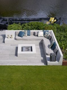 an outdoor seating area next to a body of water