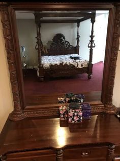 a bedroom with a bed, dresser and mirror