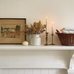 a white mantle with candles and flowers on it